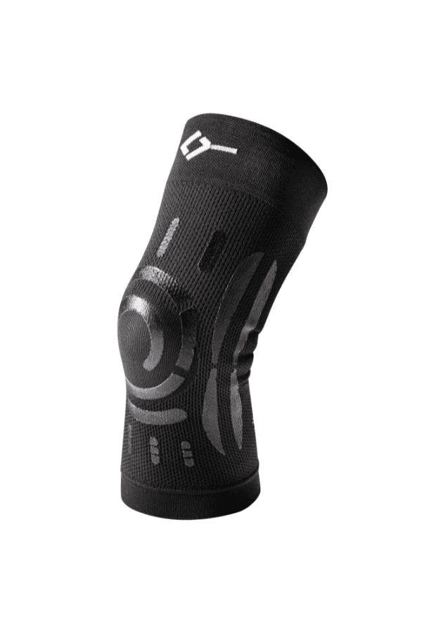 3/4 angled view of black Floky knee support brace showing open patella circular cutout with concentric spiral compression rings, Floky logo at cuff and structured compression knit body, product shot on white background