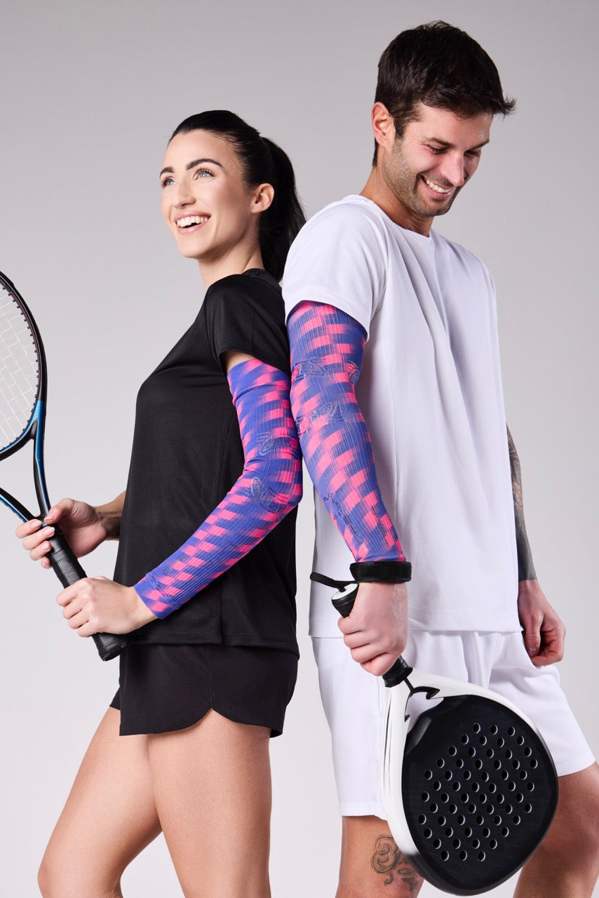 Male and female padel players wearing Floky blue and pink patterned arm sleeves, holding padel rackets and smiling, Floky 2025 collection