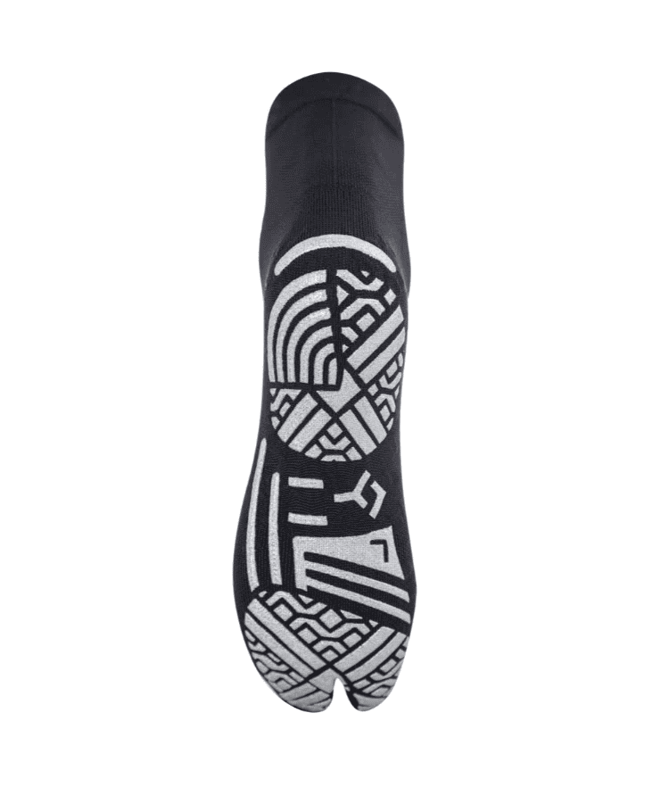 Sole view of black Floky KINETICA Silver Metallic pilates grip sock showing bold silver geometric non-slip grip pattern covering sole, split-toe design at base, product shot on white background