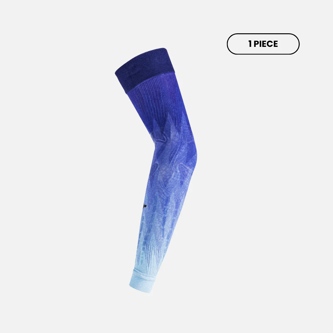 Side view of Floky No-Strain arm sleeve in Ice Comet colourway showing deep royal blue to icy aqua gradient ombre with subtle compression knit texture, single piece bent at elbow, product shot on light grey background