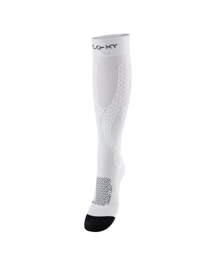Side view of white Floky Jumper Long over-the-calf compression sock with FLOKY logo at cuff, grey honeycomb zone mapping at lower leg and black toe panel, product shot on white background